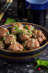 Beef meatballs in bowl with sauce, brown with sesame and parsley, tatsy snack