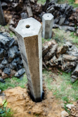 Group of foundation concrete pile put into the ground as structure base in house construction site.