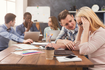 Man supporting woman reading bad news in email