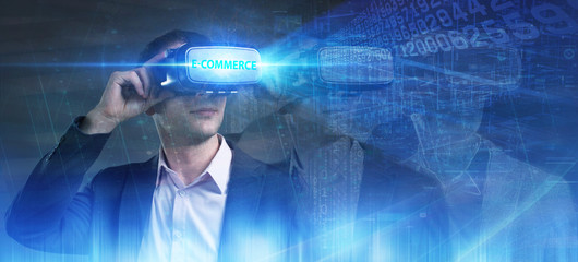 Business, Technology, Internet and network concept. Young businessman working in virtual reality glasses sees the inscription: E-commerce