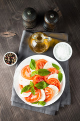 Close-up photo of caprese salad with ripe tomatoes, basil, buffalo mozzarella cheese. Italian and Mediterranean food concept. Fresh and healthy organic meal. Starter and antipasti. 