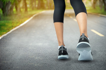 Sports background, Runner feet running on road closeup on shoe, Sport woman running on road at sunrise, Fitness and workout wellness concept.