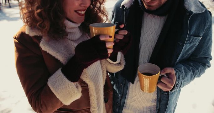 Happy friends drinking coffee on snowy day in winter