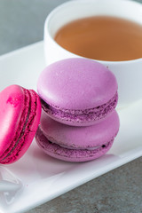 Photo of cake macarons, gift box, tea, coffee, cappuccino and flowers. Sweet romantic food macaroon concept. Morning breakfast and presents. Valentine's day concept.