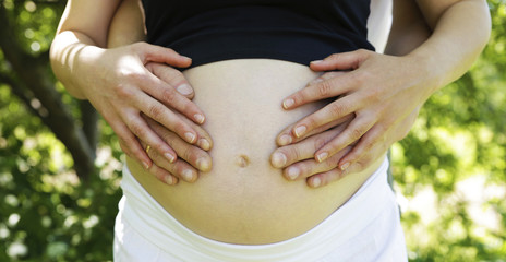 belly of a pregnant girl and hands on it