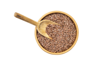 Linseed or flax seed in a wooden bowl and a spoon to the left in it seen from above isolated on white background