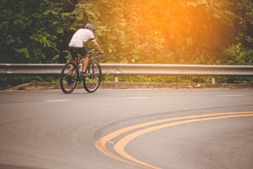 Cyclist in the park with orange sunlight scattered throughout