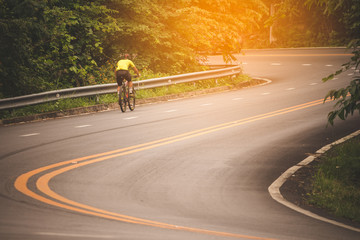 Cyclist in the park with orange sunlight scattered throughout