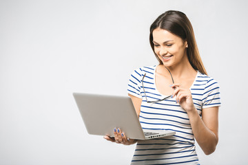 Portrait of happy young beautiful surprised woman standing with laptop isolated on white background. Space for text.