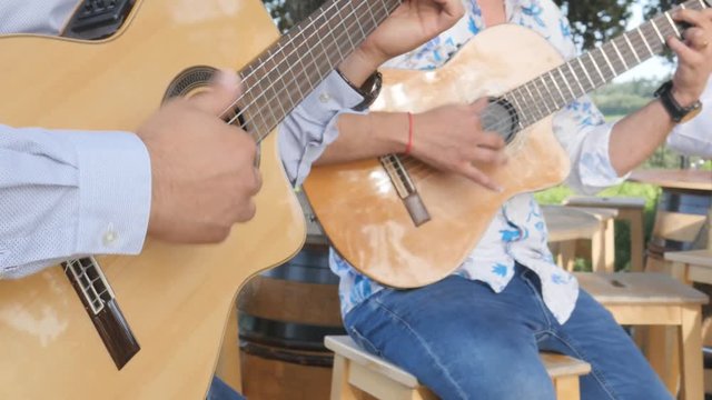 closeup detail of hand playing compas gipsy technique on folk guitar outdoor summer festival