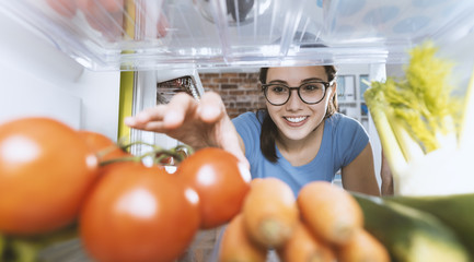 Woman taking healthy food from the fridge