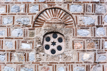 Old stone window and facade on mosque. Islamic style decoration and pattern with circle and star. Historic religion concept. Close up, selective focus