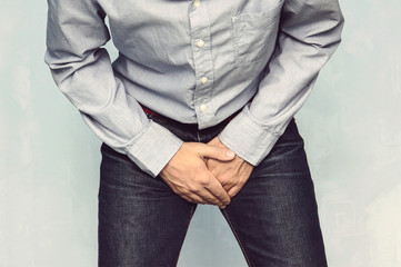Man wants to pee and is holding his bladder.