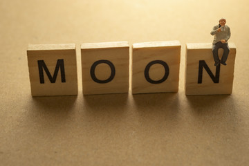 Businessman sipping coffee on MOON letter.