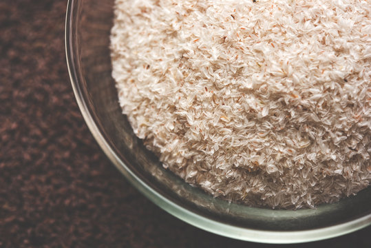 Psyllium husk or isabgol which is fiber derived from the seeds of Plantago ovata, mainly found in India. Served in a bowl over moody background. selective focus
