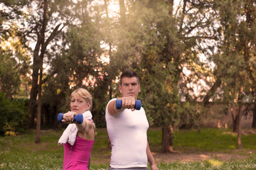 Obraz premium Couple exercising with dumbbells .
