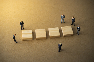 Businessmen standing around four blank wood plate