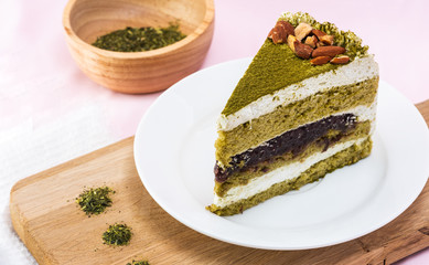 piece of matcha red bean cake and almond decorated on pink pastel background