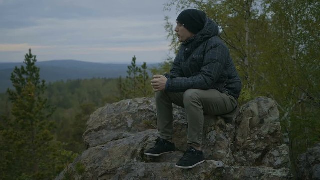 Guy is sitting in the forest