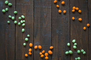 Peanuts in a colored shell, on a wooden table. Beer snacks. Top view with copy space.