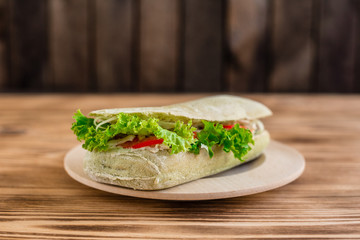 Tasty hamburger with meat and vegetables against a wooden background. Fast food. It can be used as a background