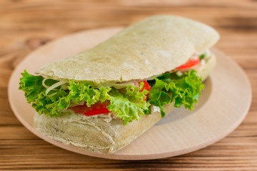 Tasty hamburger with meat and vegetables against a wooden background. Fast food. It can be used as a background