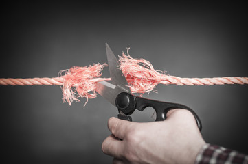 Red rope is cut with scissors./Red rope is cut up
