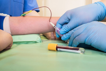 Nurse taking blood sample from a vein of a child