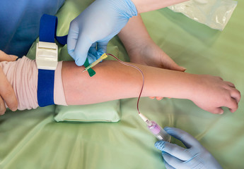 Nurse taking blood sample from a vein of a child
