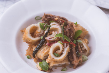 Fresh Fried Squids Calamari, Red Hot Chili Pepper and Green Mint Leaves on White Plate