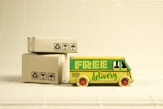 Free delivery van, vintage toy truck with cardboard boxes. Shipping concept.