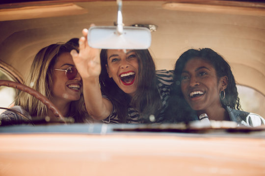 Cheerful female friends going on a road trip