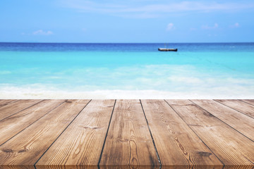 Wood table with blue sea and sand beach background 