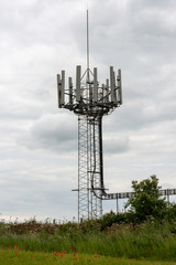 old cell phone communications tower  and large dirty overgrown satellite dish
