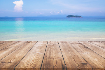 Wood table with blue sea and sand beach background 