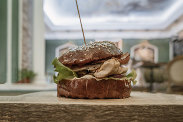 Craft beef burger on wooden table side view