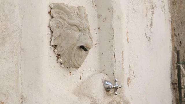 washing hands in a Small fountain in a street in Italy