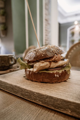 Burger on a wooden board up angle view with copyspace