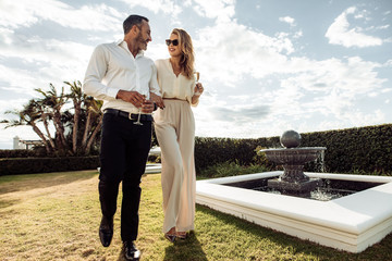 Stylish couple walking outdoors in lawn