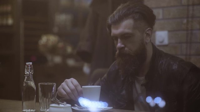 Man sitting in the restaurant, looking arround and waiting for something or someone. Handsome man sitting in the cafe