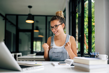 Young student passing the exam. Looking at laptop screen.