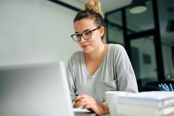 Girl in eyeglasses using laptop. Close-up.