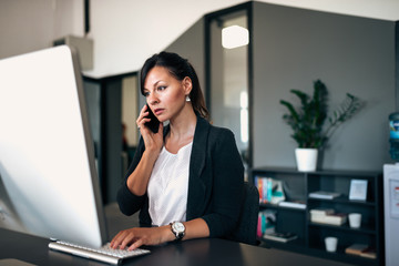 Having serious phone conversation with colleague while solving problem on the computer.