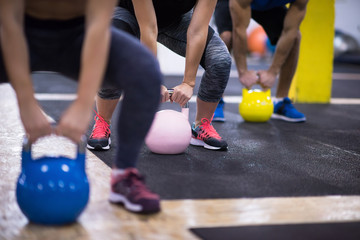 athletes doing exercises with kettlebells - Powered by Adobe
