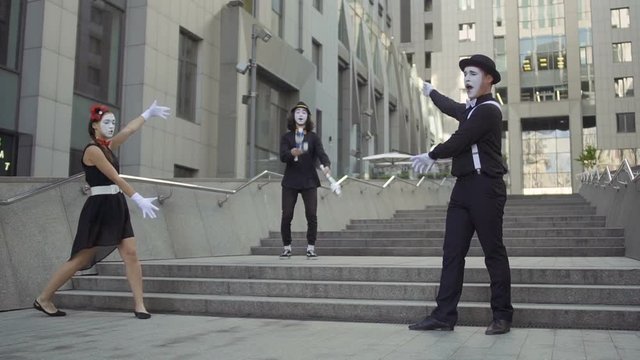 Three mimes at office center background