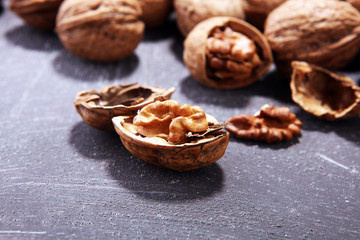 Walnut kernels and whole walnuts on rustic old table
