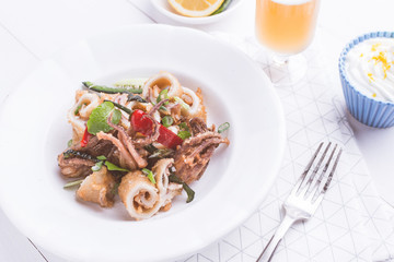 Fresh Fried Squids Calamari, Red Hot Chili Pepper and Green Mint Leaves on White Plate