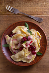 Dumplings, filled with cherries, berries. Pierogi, varenyky, vareniki, pyrohy - dumplings with filling, popular dish in many countries. View from above, top studio shot