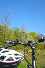 Fototapeta na wymiar View over blurred bicycle handlebar and helmet to a landscape with blue sky in the countryside of Berlin, Germany