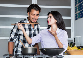 Latin american love couple cooking at kitchen